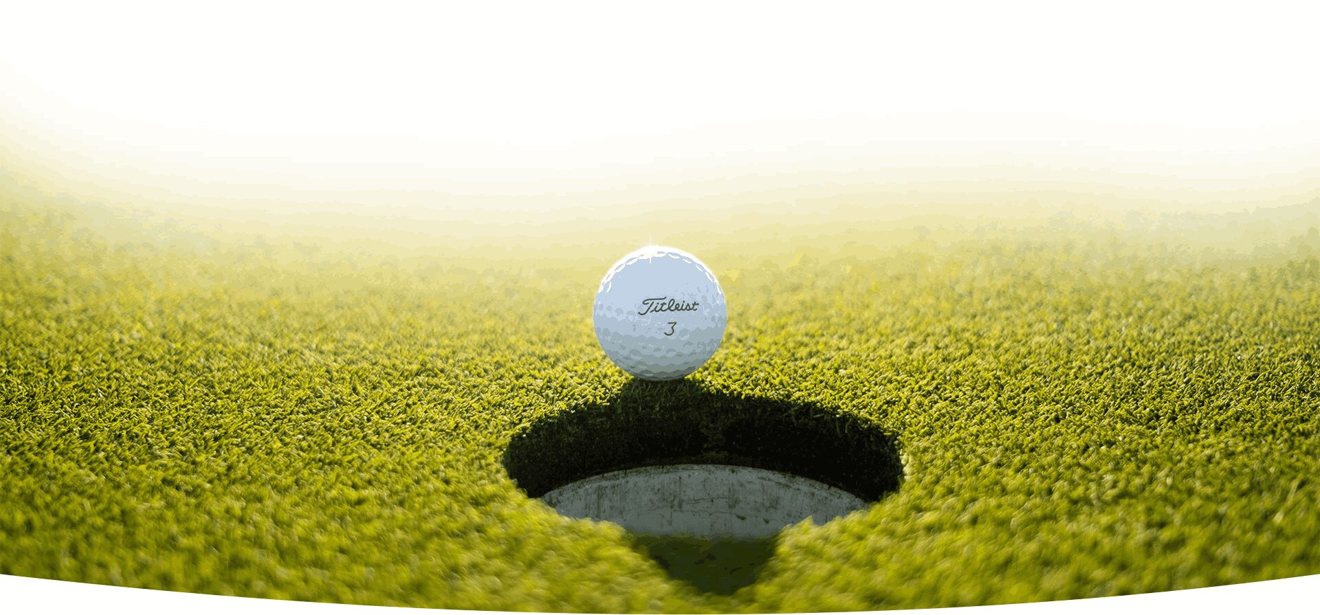White Golf Ball Near Hole on Green Grass